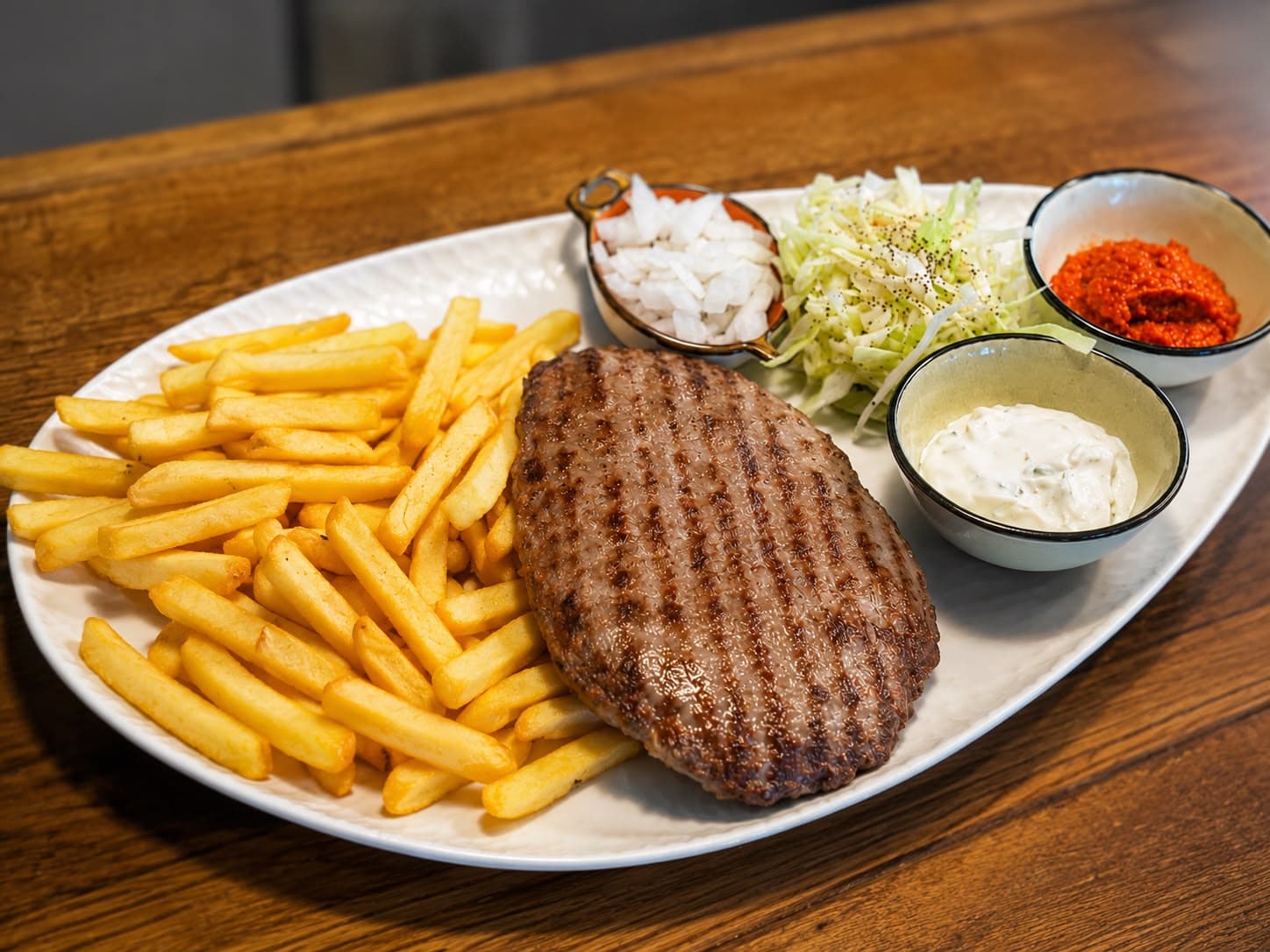 Gegrillte Pleskavica mit Pommes und Dips